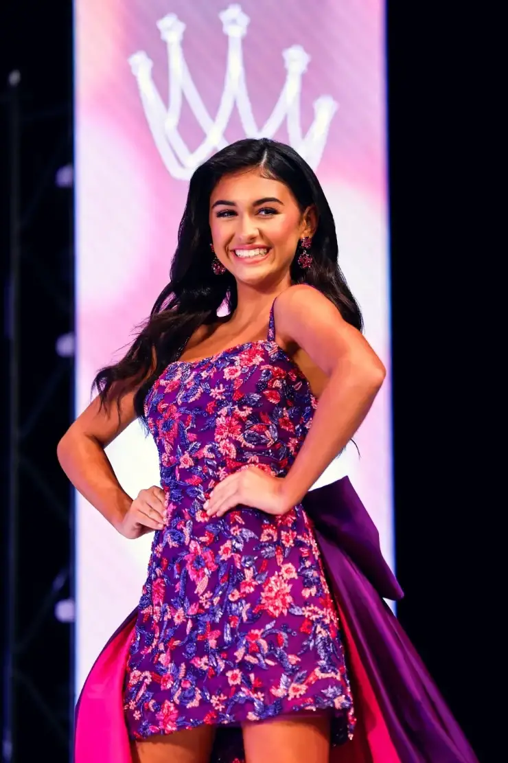 model is wearing a purple pageant dress
