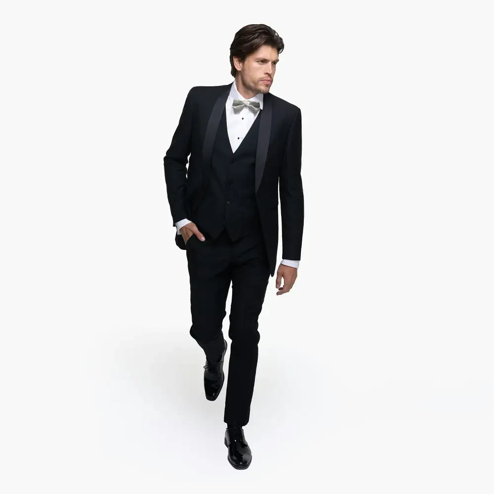 A man in a tuxedo walking confidently.