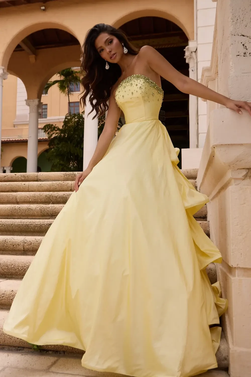 model is wearing a strapless yellow prom dress