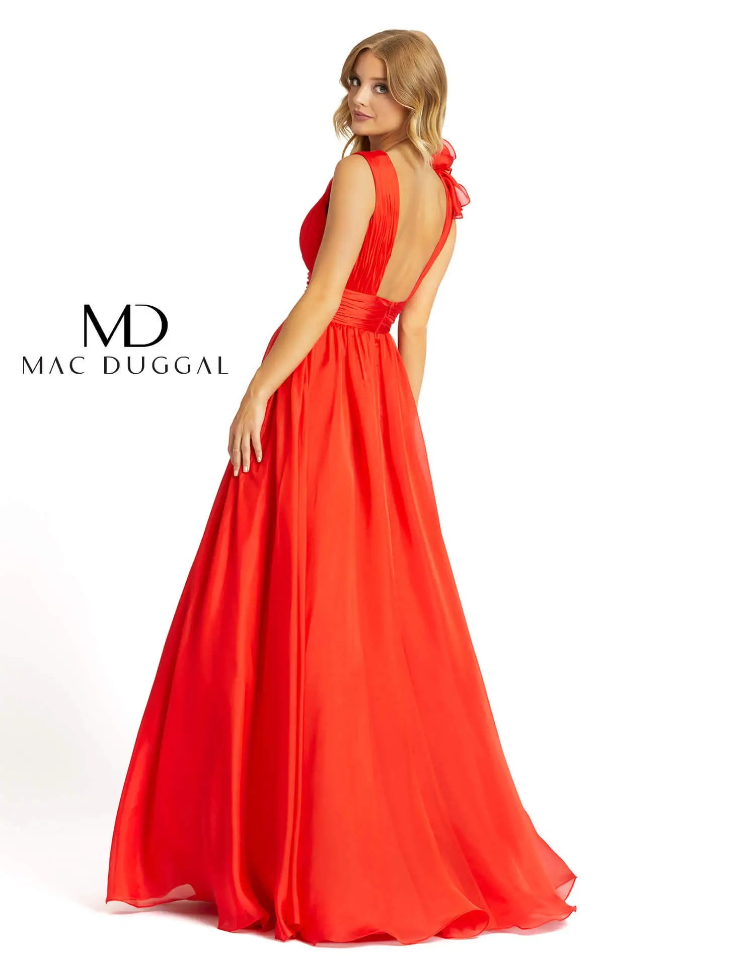 Model is wearing a sleeveless red evening gown with floral embellishments on the bodice and skirt