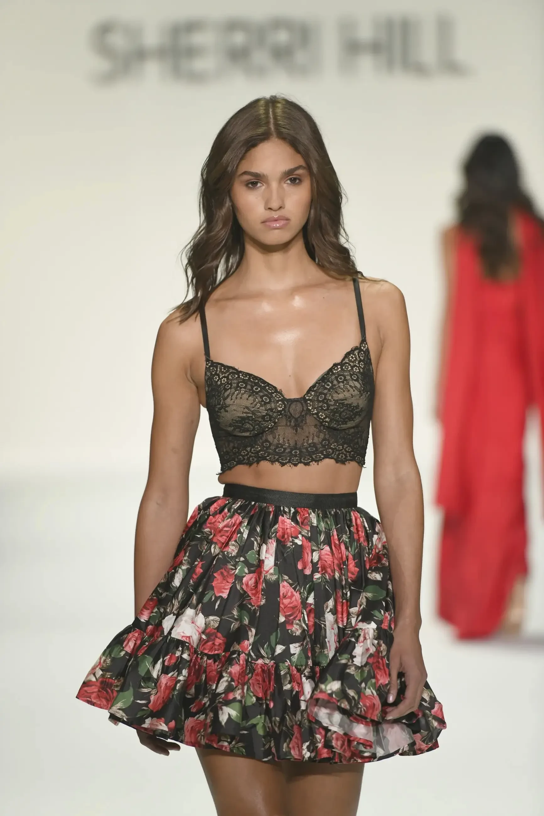 model is wearing a two piece crop top mini skirt homecoming dress set