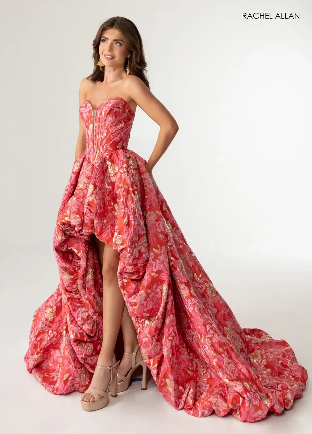 model is wearing a floral strapless high low prom dress
