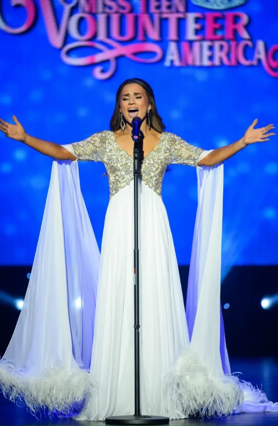 model is wearing a white pageant dress